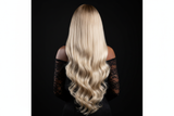 Back view of brown-skinned model wearing 613 blonde body wave wig